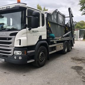 Hvit lastebil med grå container